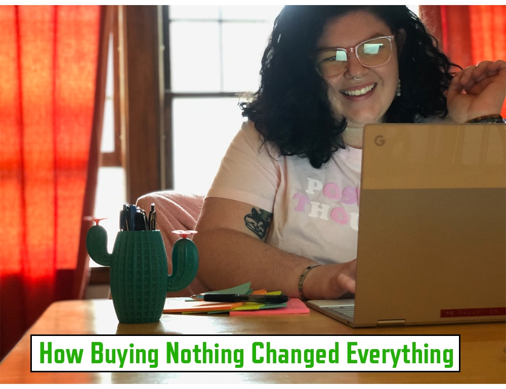 A smiling white person with dark hair and glasses with an open laptop in front of them.