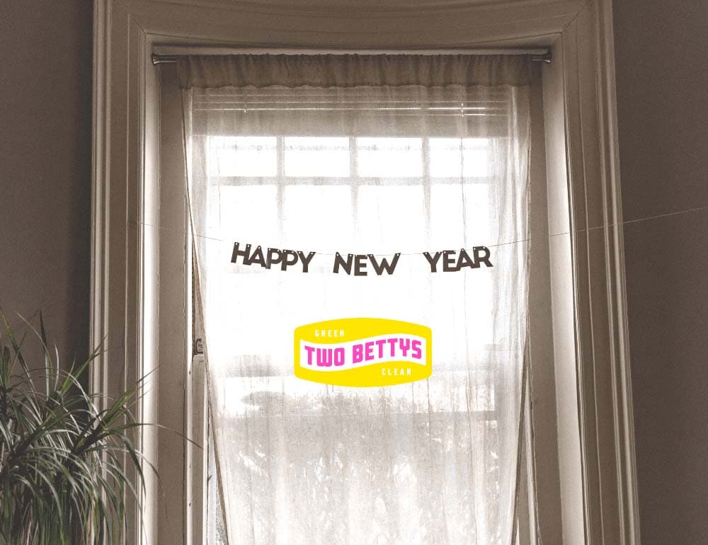 A bright window with sheer curtains and a "happy new year" banner.