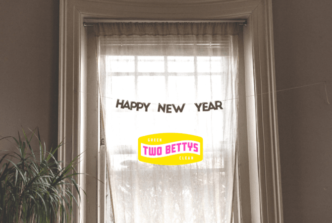 A bright window with sheer curtains and a "happy new year" banner.